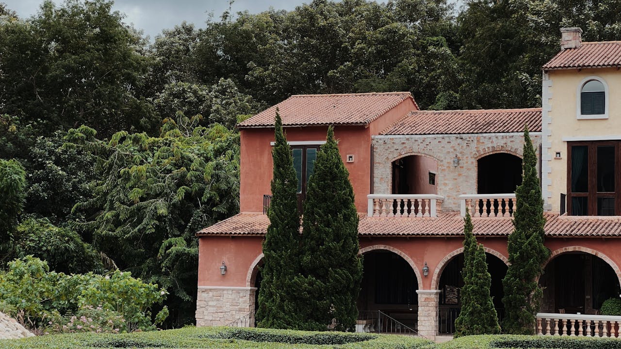 Beautiful Mediterranean villa surrounded by lush forest and landscaped garden.